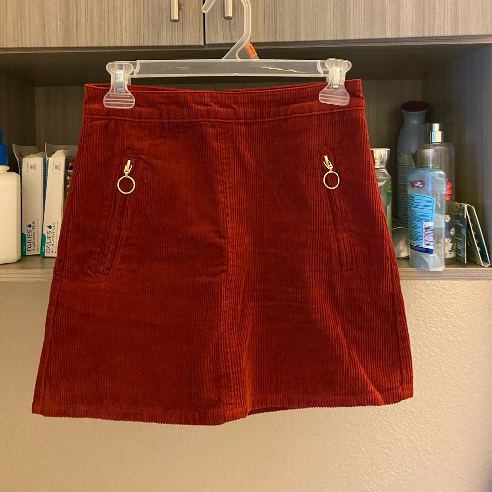 Red corduroy skirt with gold zippers.